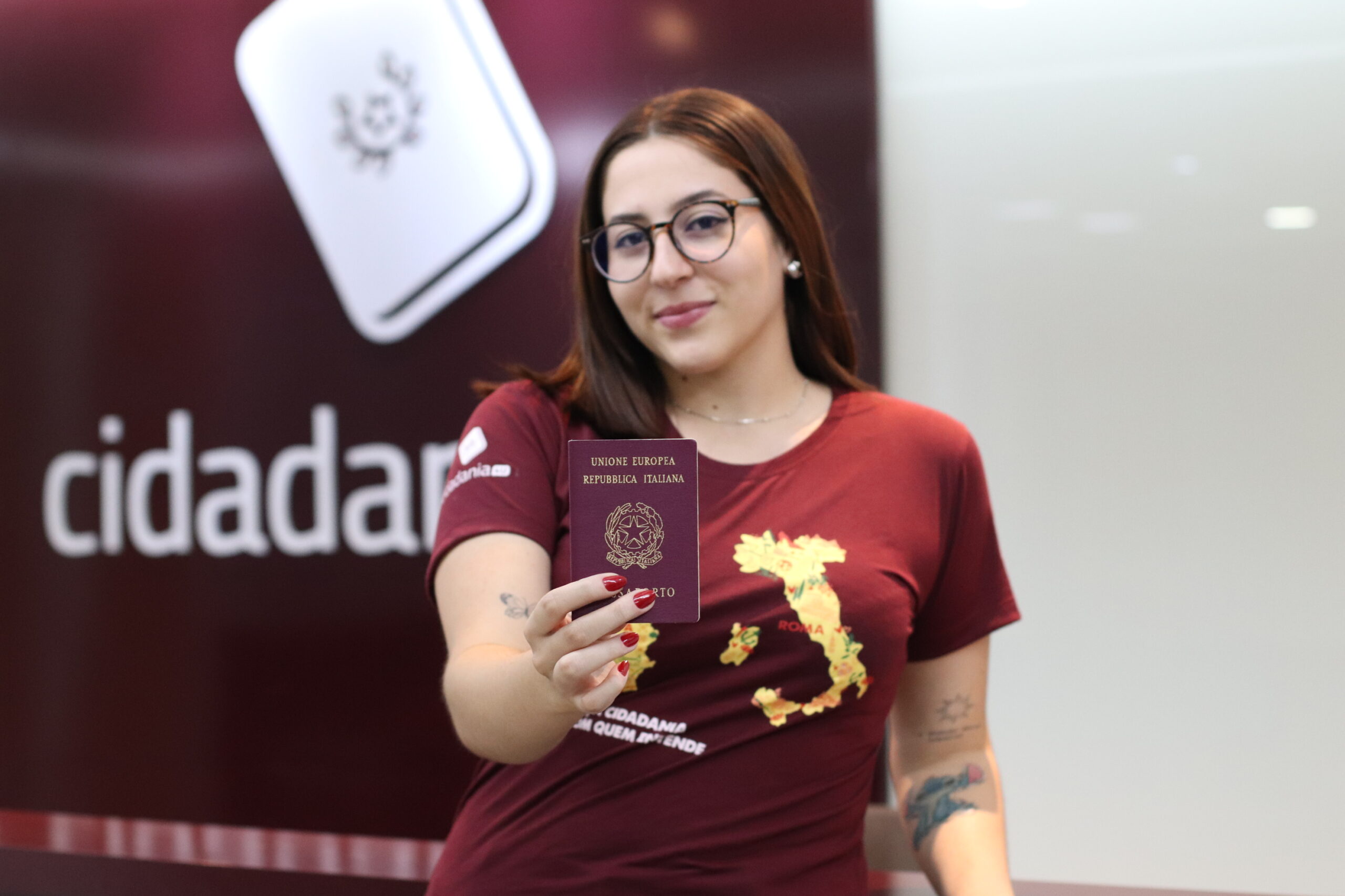 Especialista del Grupo4U con uniforme bordó mostrando un pasaporte italiano